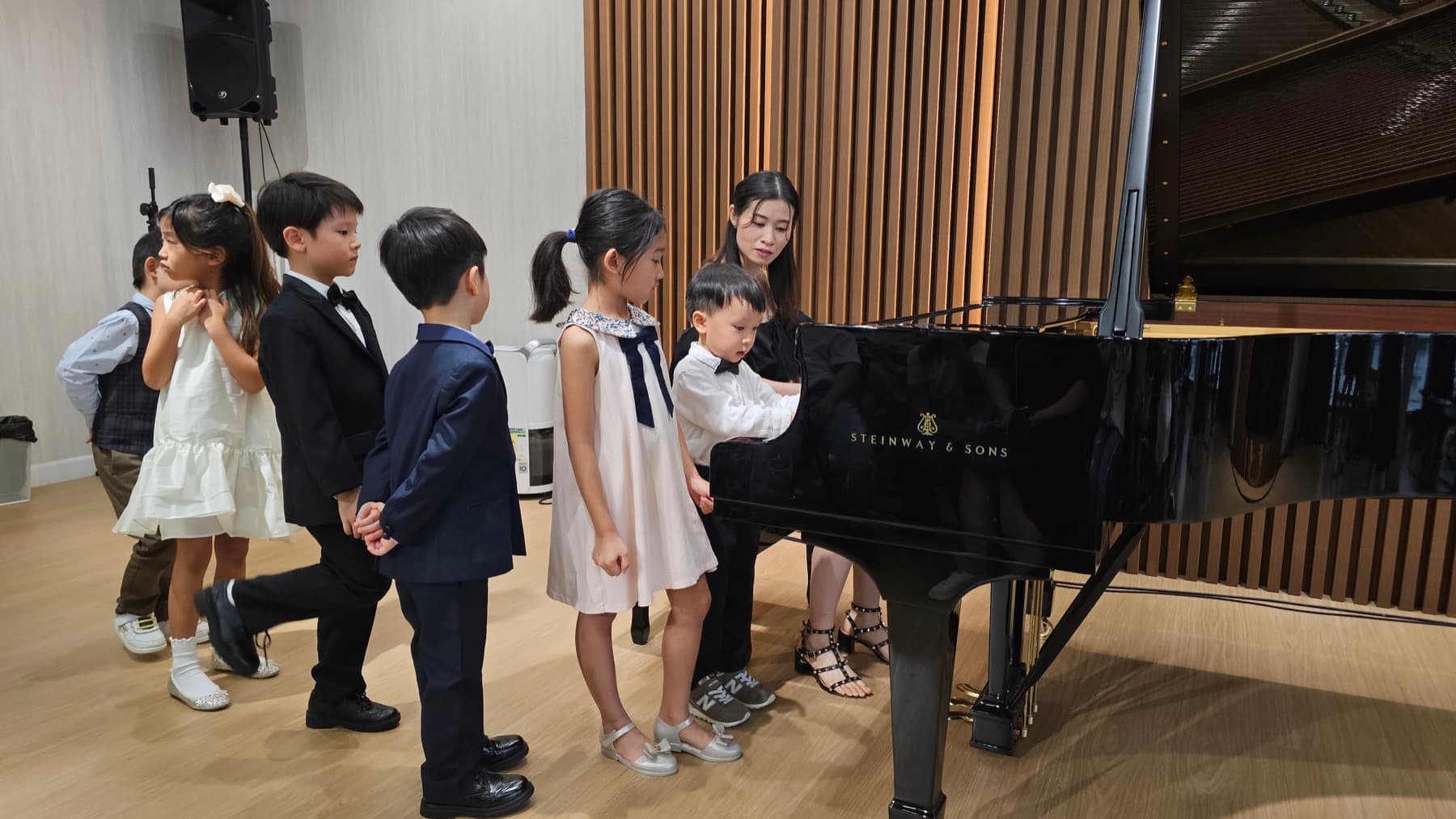 Children waiting beside a grand piano during the annual performance